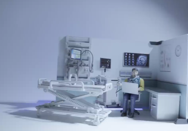 Still from video essay:

Model diorama of a doctor's office. A toy all-white gurney, the X of it's industrial height-adjusting ratchet exposed, thin white mattress wouldn't even be noticeable as such but for the equally paltry white pillow at one end.

What appears to be the flat-screen monitor of diagnostic equipment stands on a counter behind it, it's grey and blue windows and desktop the only color against what appears to be an empty literature rack on the white wall behind that.

To the right, a wide screen appears to show medical imaging, below which seated a toy action figure of with short brown hair and a thin mustache and petit goatee, a grey cowl-scarf over a blue-and-white check vest and yellow sleeves, and blue jeans, the line of articulation of their toy knees visible, a large grey laptop open before them, a grey desk behind them, a grey and white partition behind that, with a medical poster and clockface not so much hung on the partition as printed upon it.