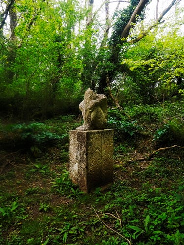 A sculpture of an unspecified creature sitting on a pedestal. It appears to be made of leaves.