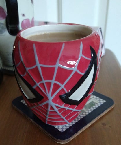 Mug of tea on a bedside cabinet, with the face of Spiderman 