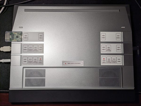 the bottom side of my framework 16 laptop with compatibility label stickers added next to all 6 expansion card slots to indicate which ones support USB4, Display output, 240W Charge, and which ones have high power consumption for USB-A