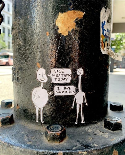 Streetart. A small sticker with two simply drawn figures was placed in the middle of a dark, iron hydrant.
The fat man on the left says to the thin man on the right: "Nice weather today". The short man replies: "I have diarrhea".
Info: 
The simply drawn white misshapen men with long necks and different sized bellies and heads have numerous adventures in New York. Sara Lynne Leo is a muralist, street artist and mental health advocate whose street art is attracting a lot of attention throughout New York City. Sara Lynne is a gender non-conforming artist, and her artwork takes the form of hand-painted comics that contain witty, sardonic, and often therapeutic messages.