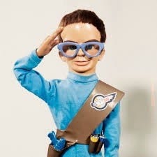 A picture of Brains, a Supermarionation puppet character from the famous TV series “Thunderbirds”. He is wearing the International Rescue uniform of a blue tunic with a brown sash. He is saluting.