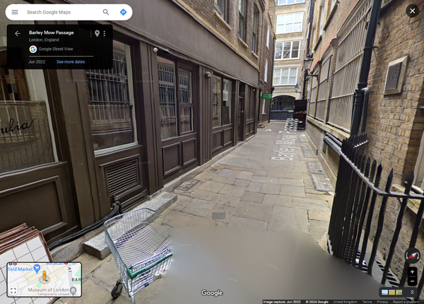 An image from Google Streetview of narrow alleyway with an abandoned shopping trolley in it
