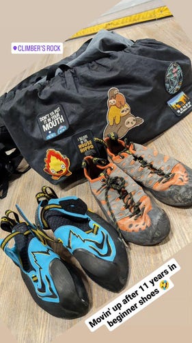 Instagram story showing two pairs of climbing shoes (one older, one brand new) against a rope bag.

In picture caption reads: Movin' up after 11 years in beginner shoes 🤣