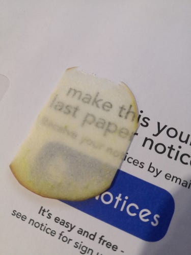 A slice of apple resting on top of some paper. You can read text printed on the paper through the apple, demonstrating how thin the apple is. The exact text isn't important, it's about paper notices