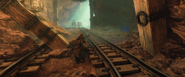Aloy sneaks through a mining tunnel. Minecart rails run along the floor of the tunnel, leading to a collapsed bridge spanning a large chamber. Light cascades down from an opening in the ceiling, illuminating dust articles in the air. The tunnel supports are constructed of iron banded square cut timbers with strong wood grain. One of the timbers is tipped over, showing a tunnel collapse.