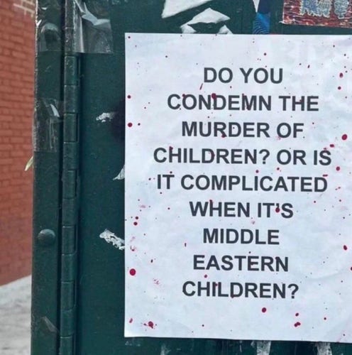 Poster, apparently blood-spattered reads: 

DO YOU
CONDEMN THE MURDER OF CHILDREN? OR IS IT COMPLICATED WHEN IT'S MIDDLE EASTERN CHILDREN?