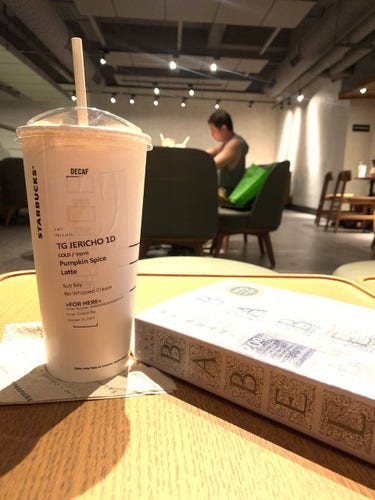A copy of the book "Babel" by RF Kuang, beside a pumpkin spice latte