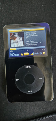 Newly restored 5th generation black iPod running Rockbox firmware and playing "Rise of the Idiots" by Joe Ressington