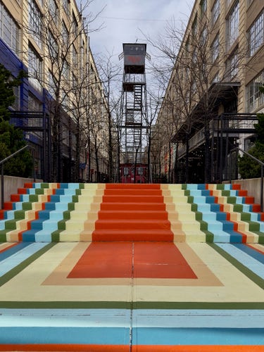 Bright painted steps of different colors leading up to one of the outdoor spaces in Industry City