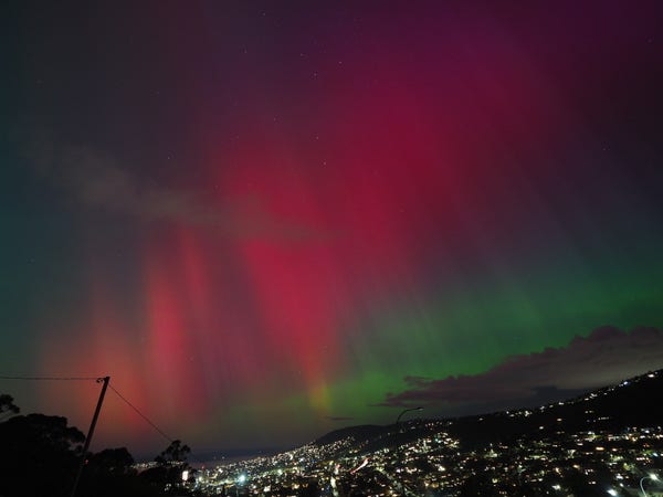 Red, green and purple aurora over the lights of South Hobart and Mt Nelson