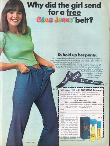 a petite woman hold open her blue jeans showing how baggy around the waist they are and in need of a belt. 