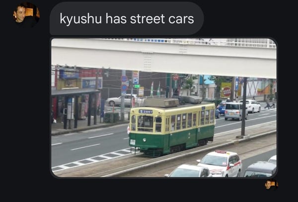 Text from husband: Kyushu has street cars
Image of a green and yellow street car on a Japanese street