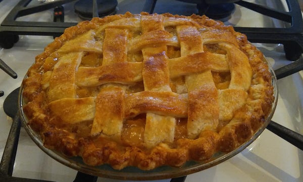 A golden-coloured pie is shown cooling. It has a lattice of pastry on the top and looks rather crispy and good, if I do say so myself.