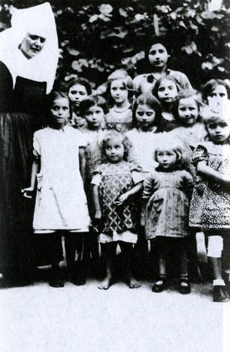 Group of children - girls standing next to a nun. Roma children in Mulfingen orphanage.