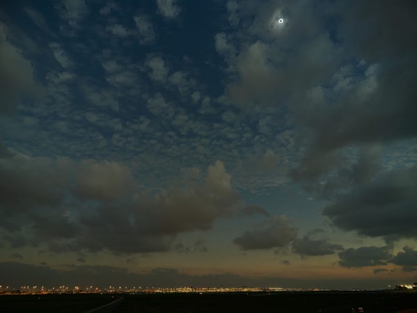 Eclipse, as seen at DFW airport. Wide view. The sun appears as a bright ring in a dark sky
