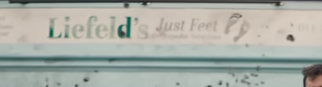Screencap of the Deadpool trailer showign a storefront sign that says "Liefelds' Just Feet"