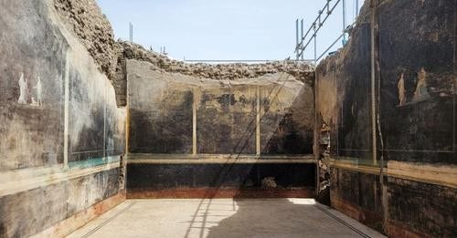 blackened walls of a chamber in a house in Pompeii still have distinct traces of fresco paintings.