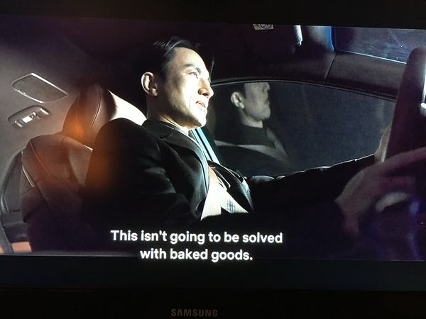 Man in a business suit, driving, says, “This isn’t going to be solved with baked goods.” (Kim Byung-chul in “Doctor Cha.”)