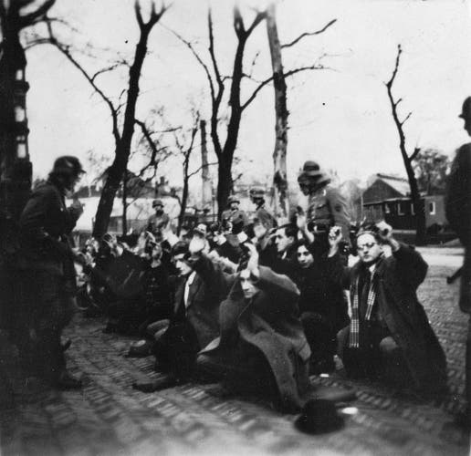 Arrest of Dutch Jews by the Nazis, February 1941. The Jews are squatting on a cobble stone street, hand in the air, as Nazis aim their guns at them. By Fotocollectie Rijksvoorlichtingsdienst, Fotograaf onbekend - Nationaal Archief and Nationaal Archief, Public Domain, https://commons.wikimedia.org/w/index.php?curid=37998785