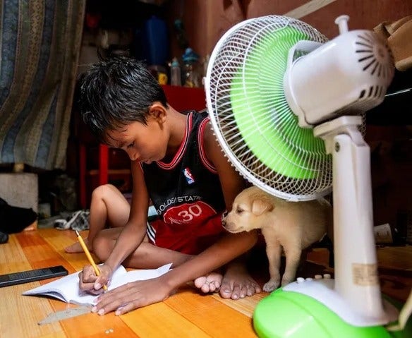 A student answers his learning module following the suspension of in-person classes while a cute whitish puppy is next to him, inside his house in Manila, Philippines, April 26, 2024.

REUTERS/LISA MARIE DAVID