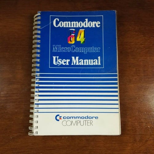 A photo of the user manual for the C64 computer lying on a desk