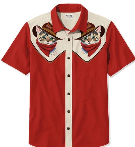 A 70s style cowboy button up short sleeved red shirt, with a cream colored seam down the front, and cream colored bandana-shaped sections for each shoulder. Instead of the traditional plain or checked design, each shoulder section has an image of a cat cowboy, wearing a red bandana and a crush-top cowboy hat.
