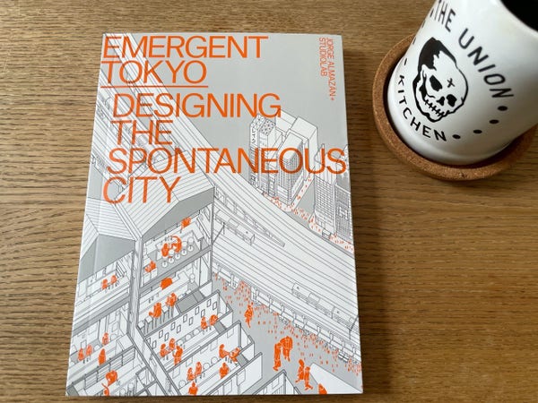 A book called “Emergent Tokyo: Designing the Spontaneous City,” by Jorge Almazán & Studiolab, sitting on my coffee table with my Union Kitchen coffee mug grinnin’ beside it.