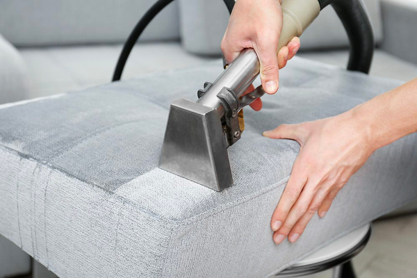 A steam cleaner being used on a cushion, it is certainly wet.